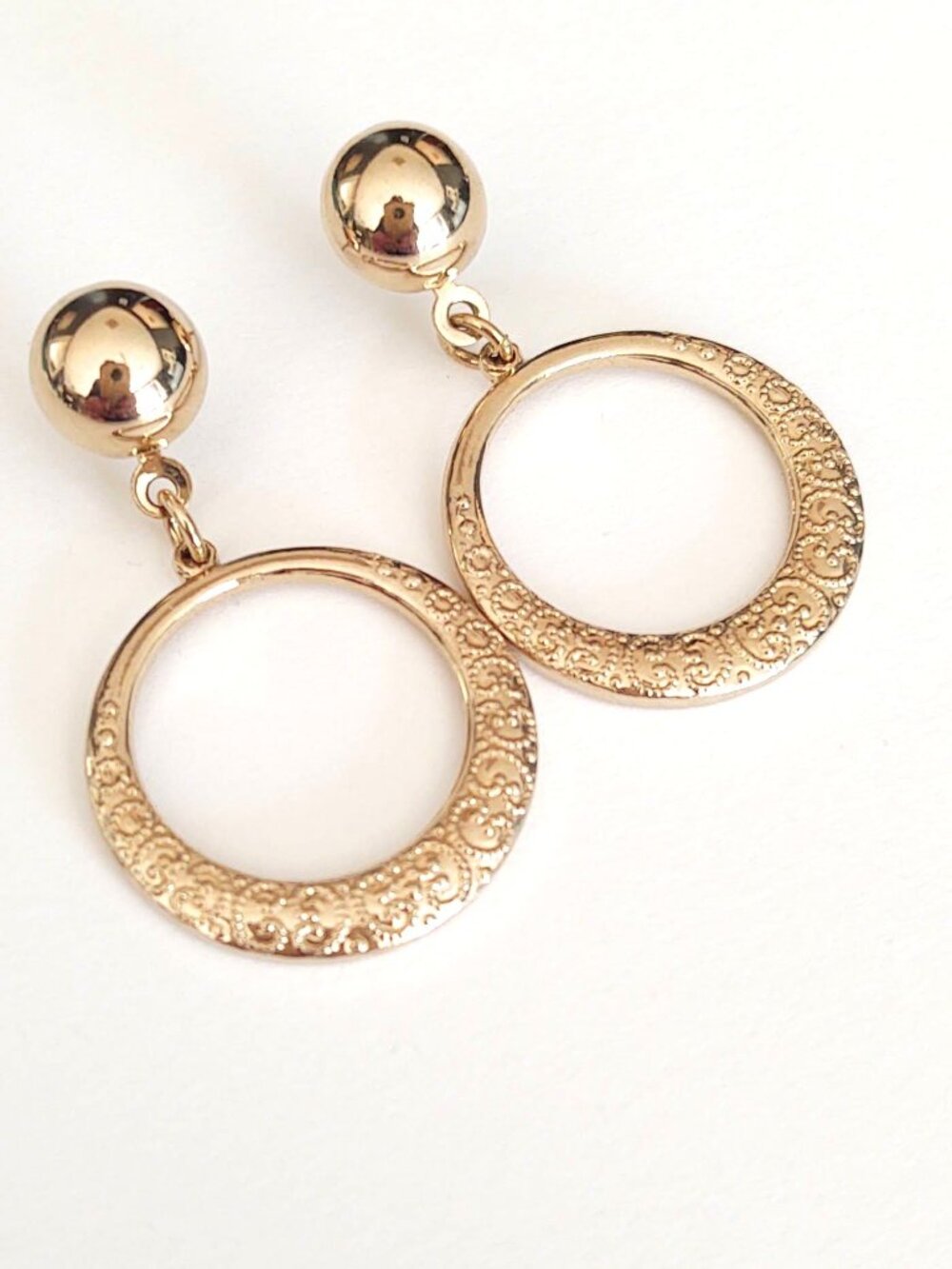 Gold tone textured drop hoop earrings